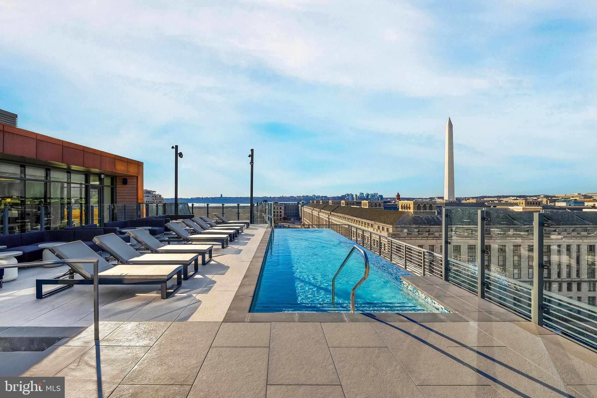 300 12th Street Southwest, Unit PH05 Washington, DC 20024 - Photo 18 of 28 a swimming pool with outdoor seating and city view