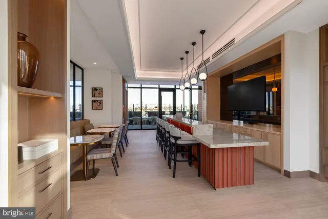 a living room with furniture floor to ceiling window and a flat screen tv