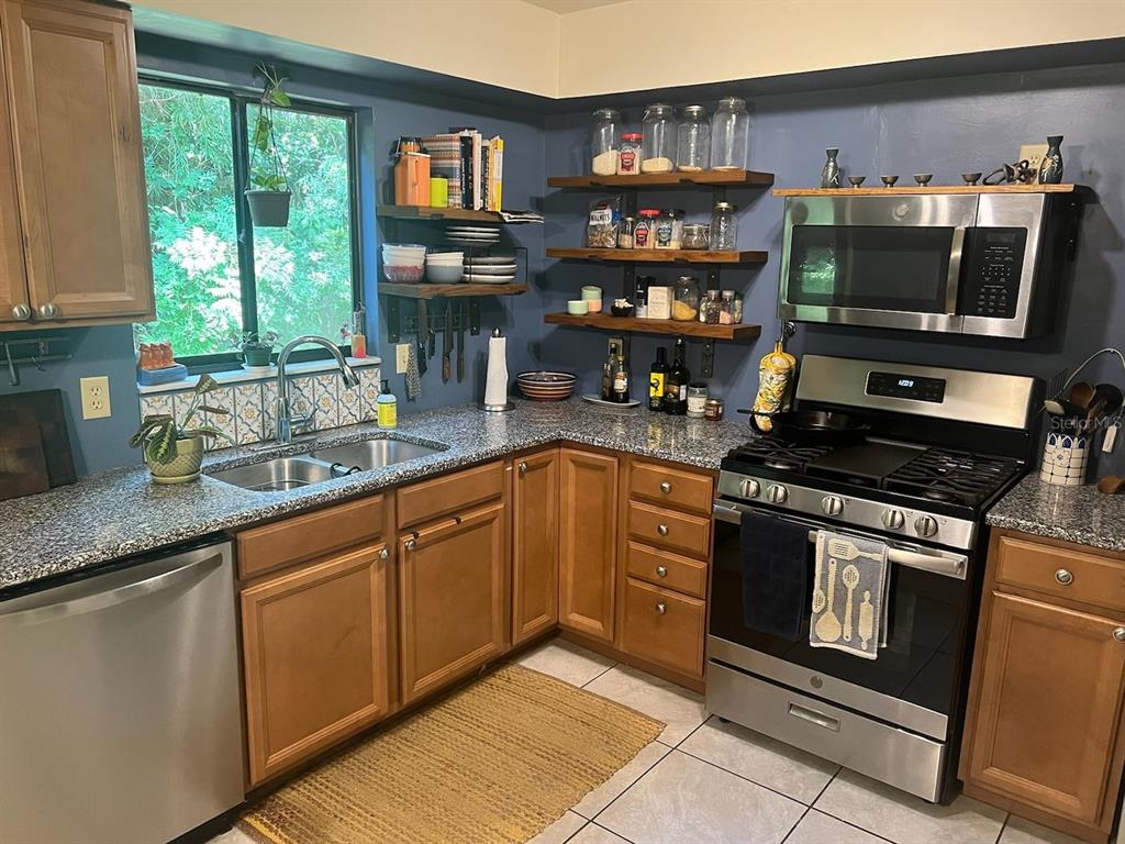 3402 Northwest 2 Street Gainesville, FL 32609 - Photo 3 of 16 a kitchen with stainless steel appliances granite countertop a stove and a sink