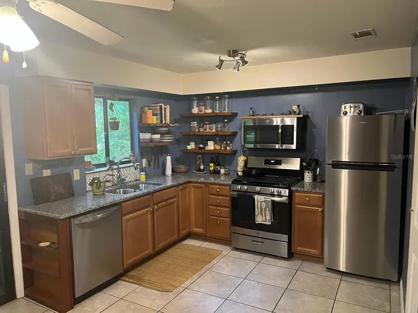 a kitchen with stainless steel appliances granite countertop a refrigerator and a sink