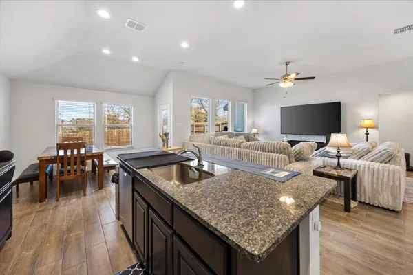 a living room with granite countertop kitchen island furniture and a wooden floor