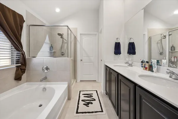 a bathroom with a tub sink and mirror