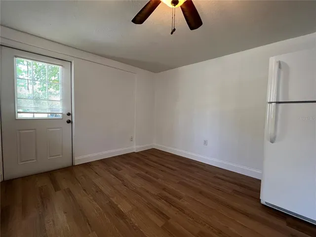 a view of an empty room with window and wooden floor