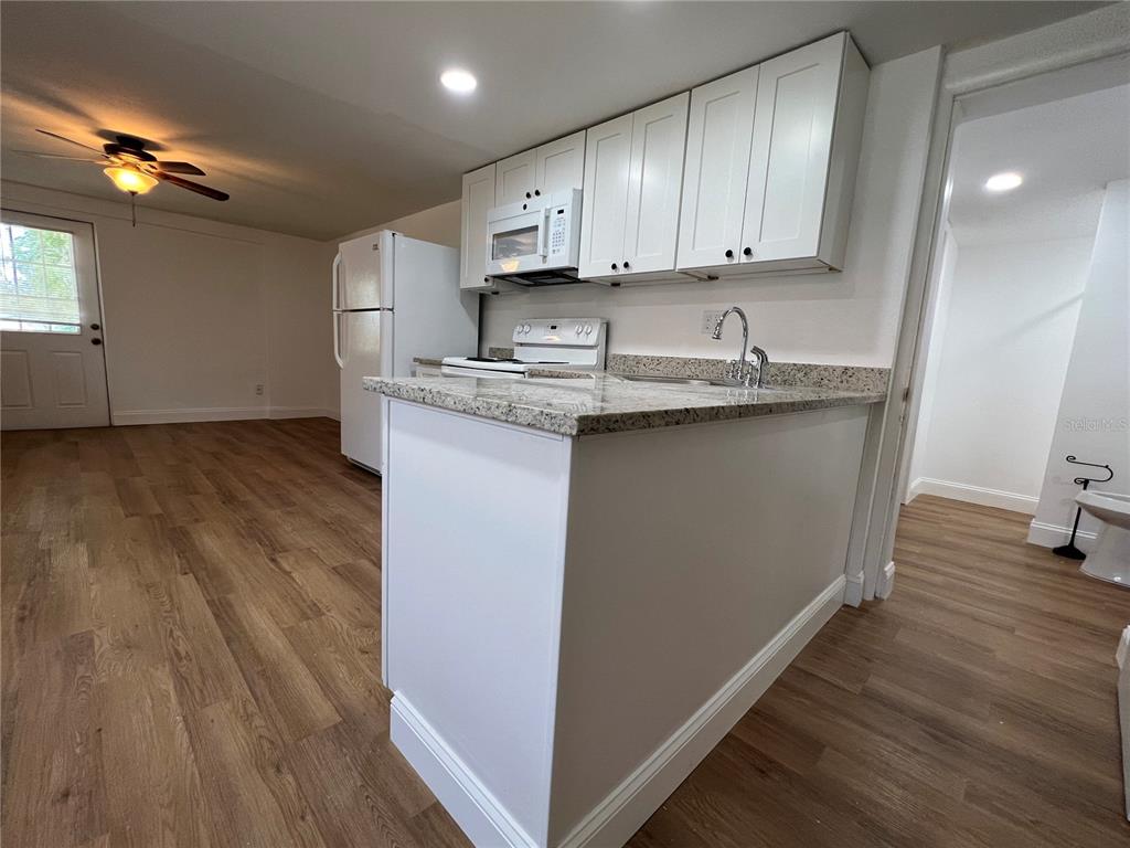 2120 10th Street St. Cloud, FL 34769 - Photo 4 of 8 a kitchen with granite countertop wooden cabinets and a sink