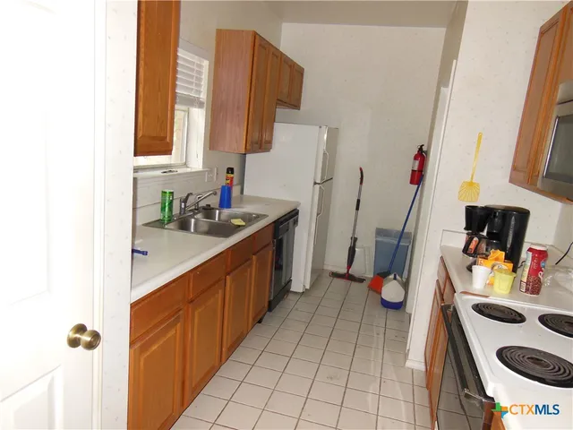 a kitchen with stainless steel appliances a sink stove and cabinets
