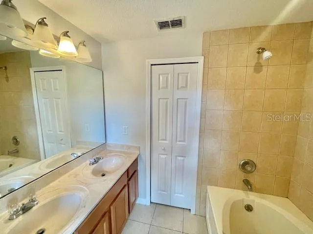 a bathroom with a tub sink shower and mirror