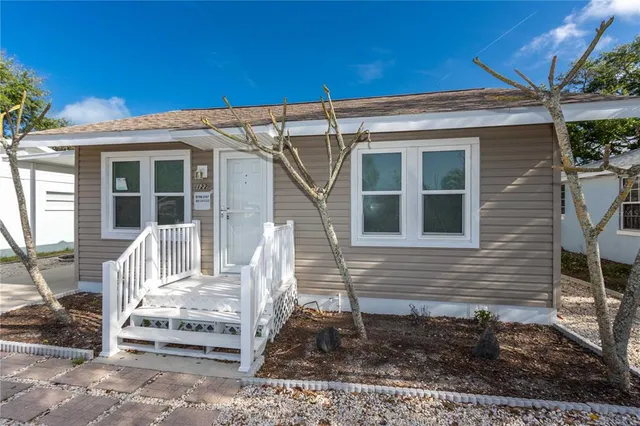 a view of wooden house with a small yard