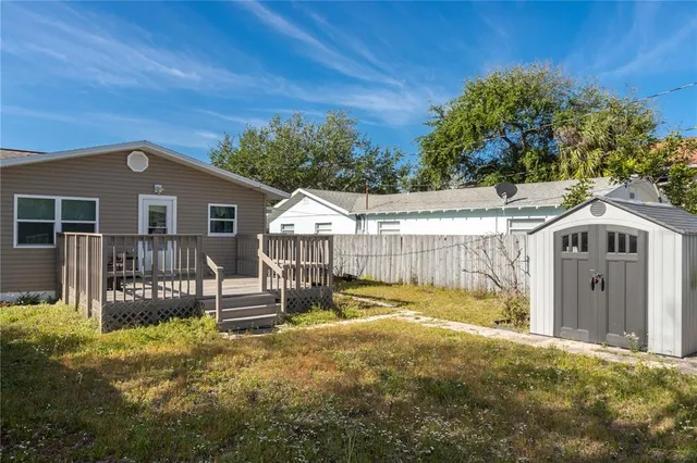 a view of a house with a small space and a wooden deck