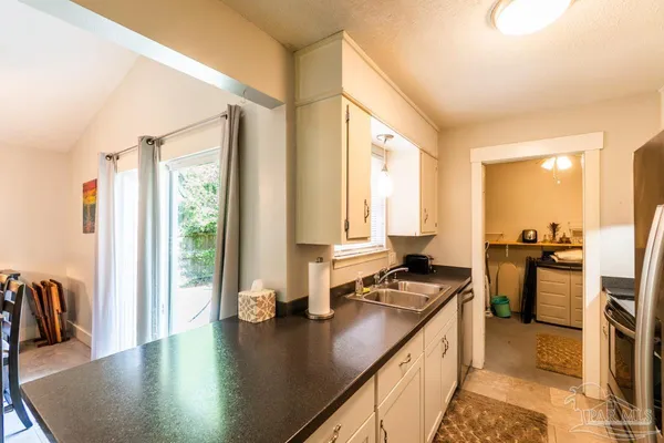 a kitchen with sink refrigerator and large window