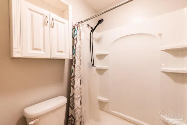 a bathroom with a toilet and a shower