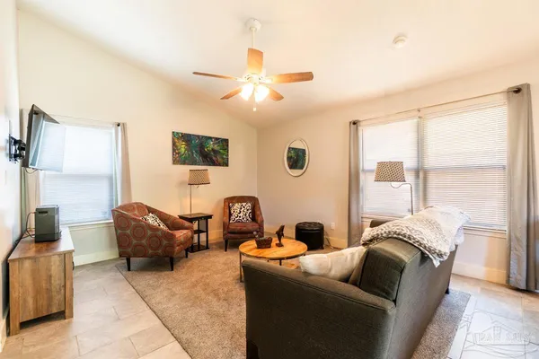 a living room with furniture a large window and a chandelier