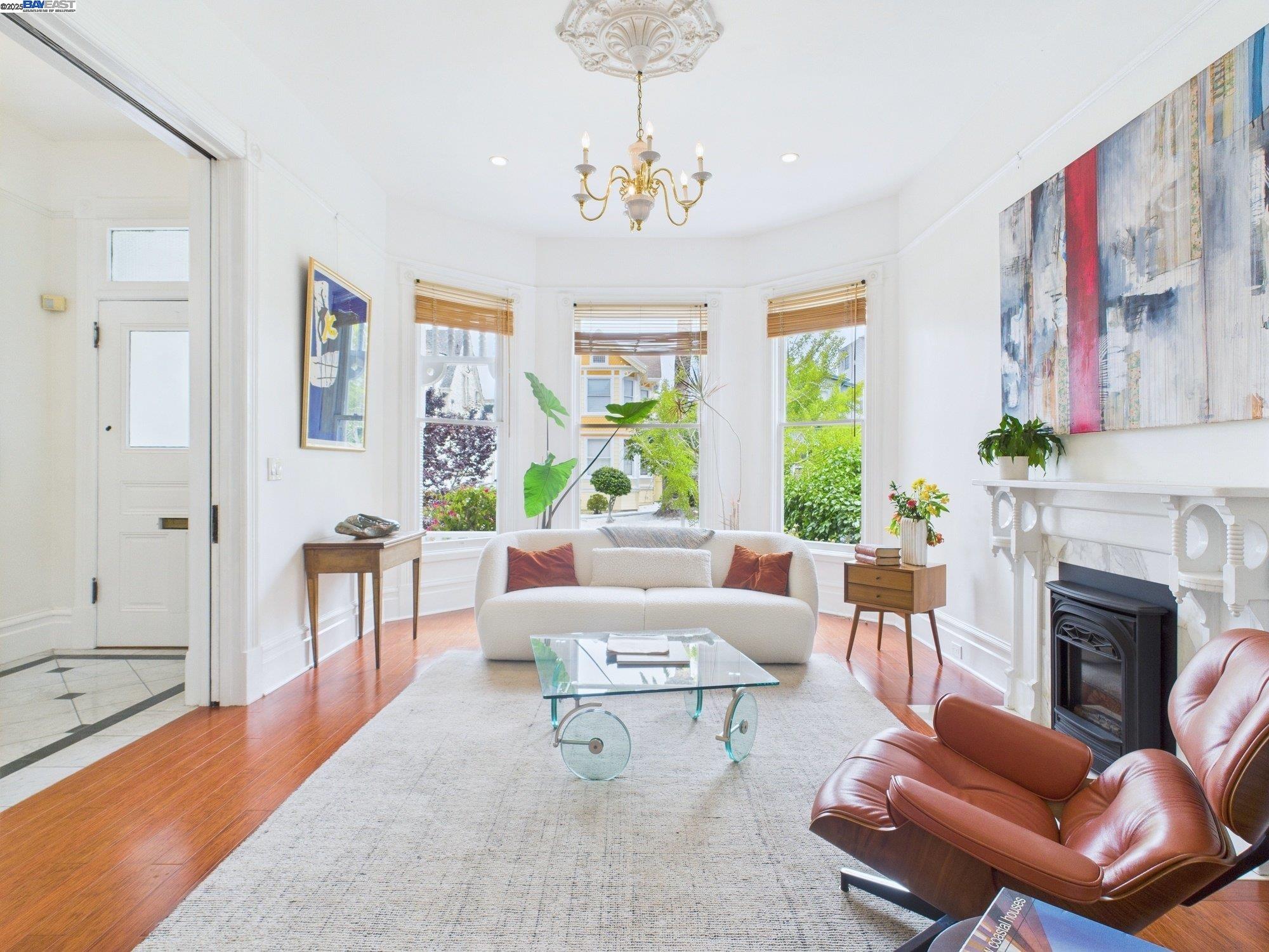 a living room with furniture a chandelier and a fireplace