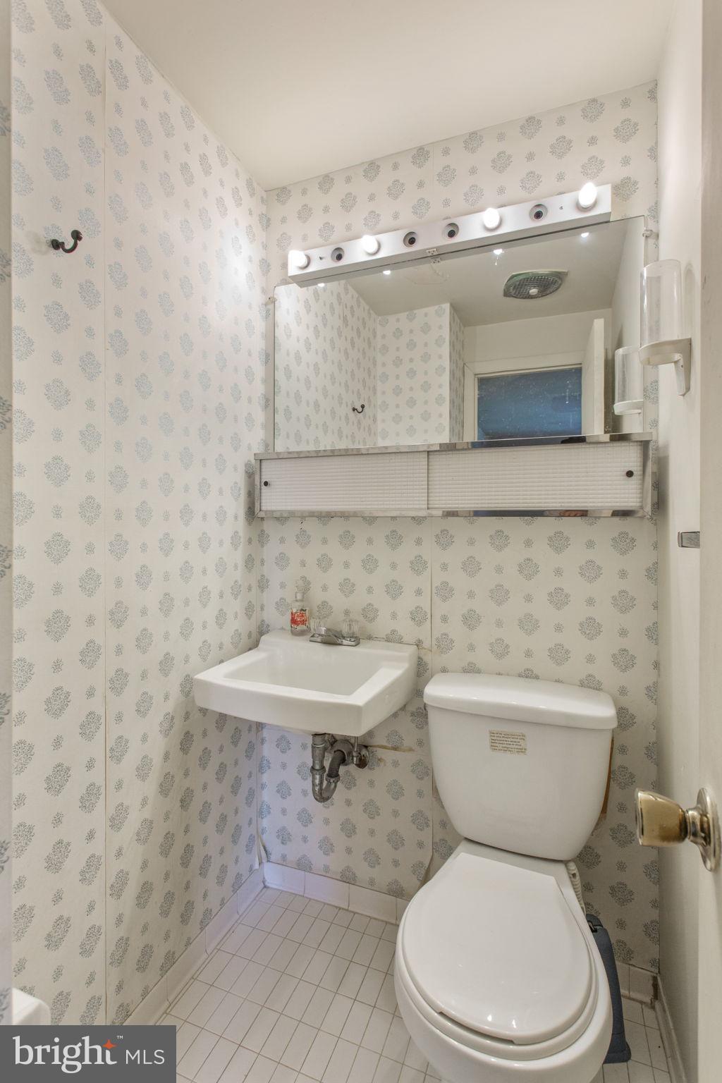 5655 Chelwynd Road Halethorpe, MD 21227 - Photo 17 of 35 a bathroom with a toilet a sink and mirror