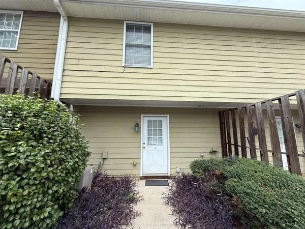 a front view of a house with plants and porch