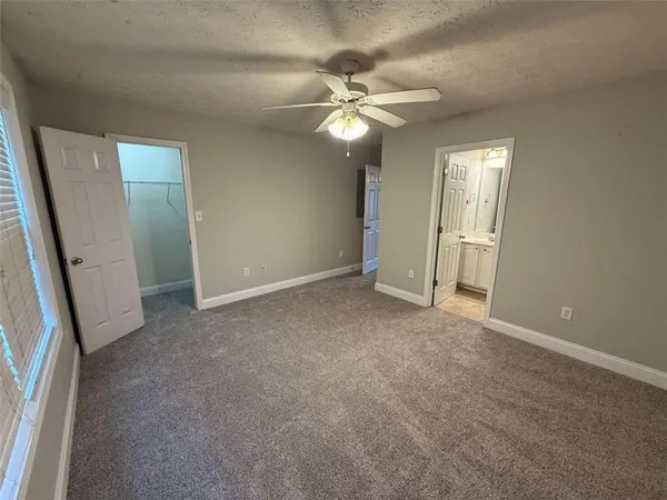an empty room with windows and fan