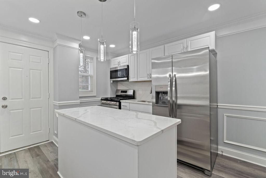 300 Denison Street Baltimore, MD 21229 - Photo 11 of 25 a kitchen with kitchen island a counter top space appliances and cabinets