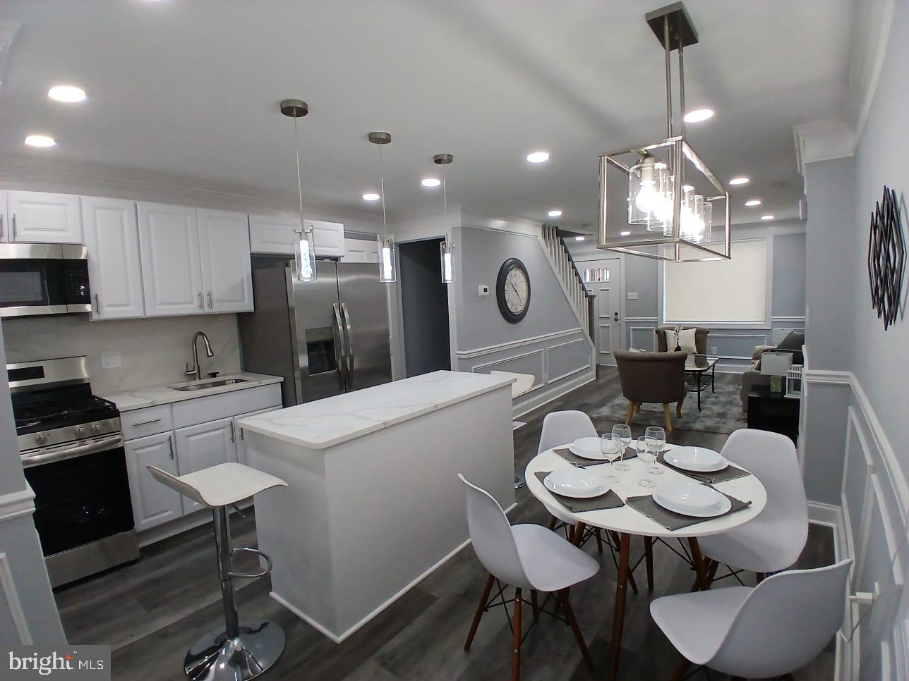 300 Denison Street Baltimore, MD 21229 - Photo 12 of 25 a kitchen with a dining table cabinets appliances and wooden floor