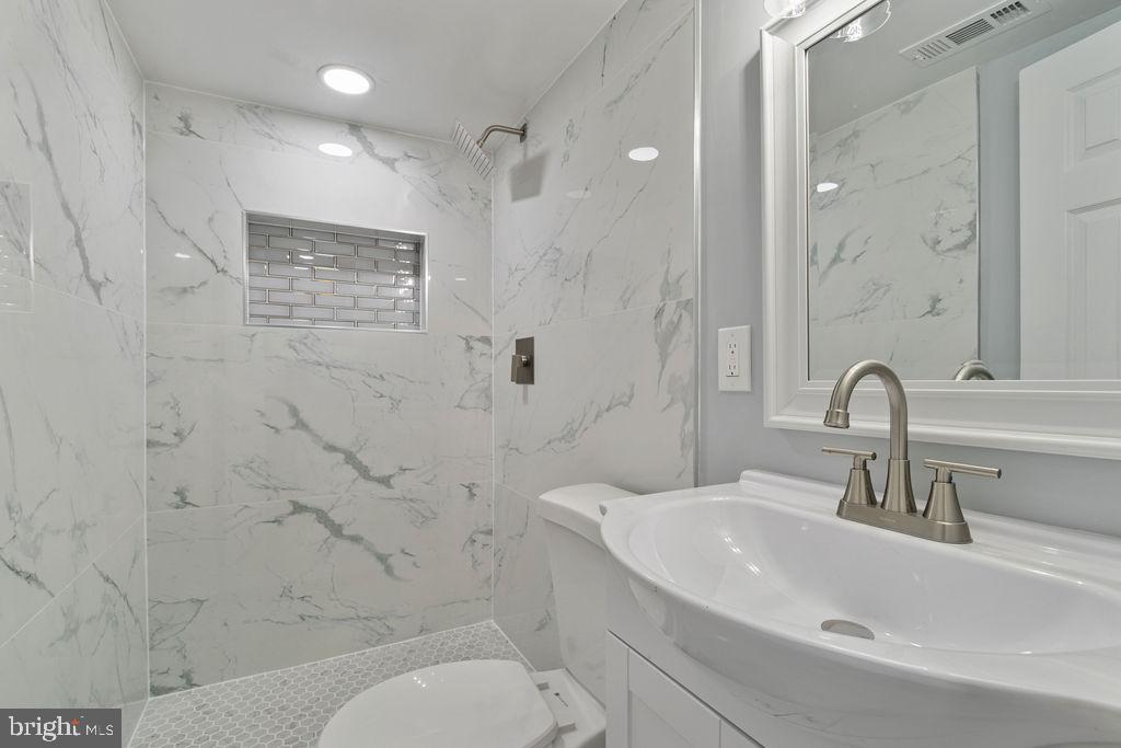 300 Denison Street Baltimore, MD 21229 - Photo 17 of 25 a bathroom with a sink a toilet and shower