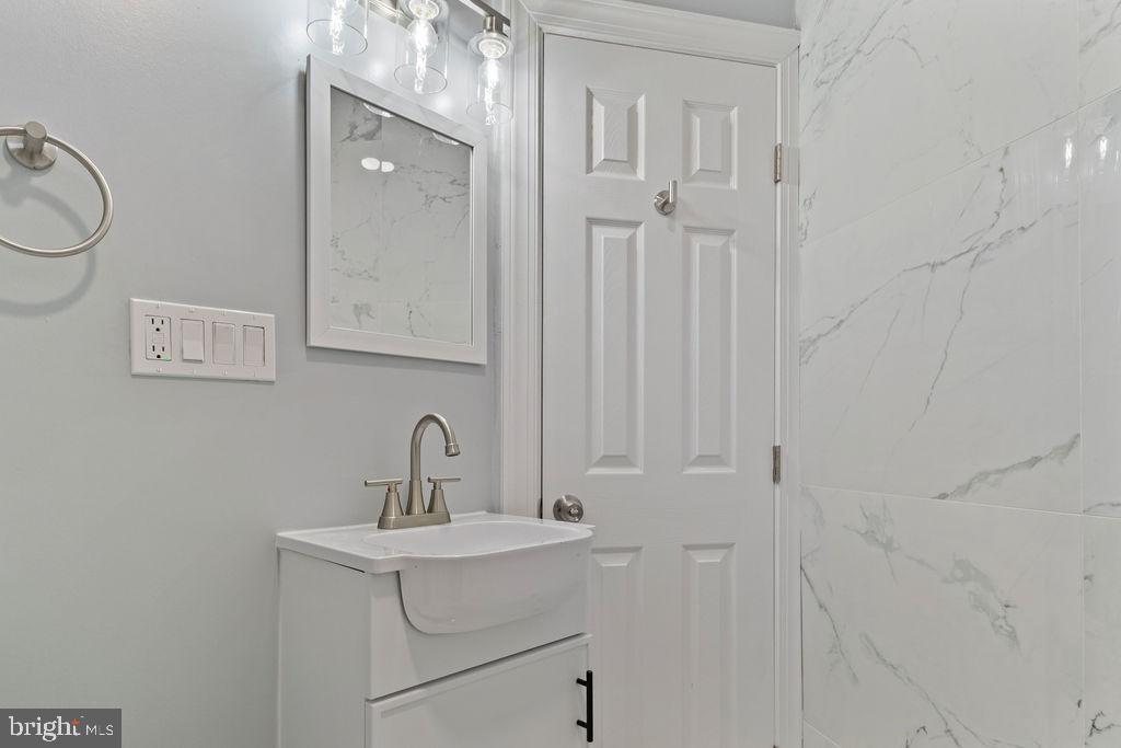 300 Denison Street Baltimore, MD 21229 - Photo 19 of 25 a bathroom with a sink a toilet and shower