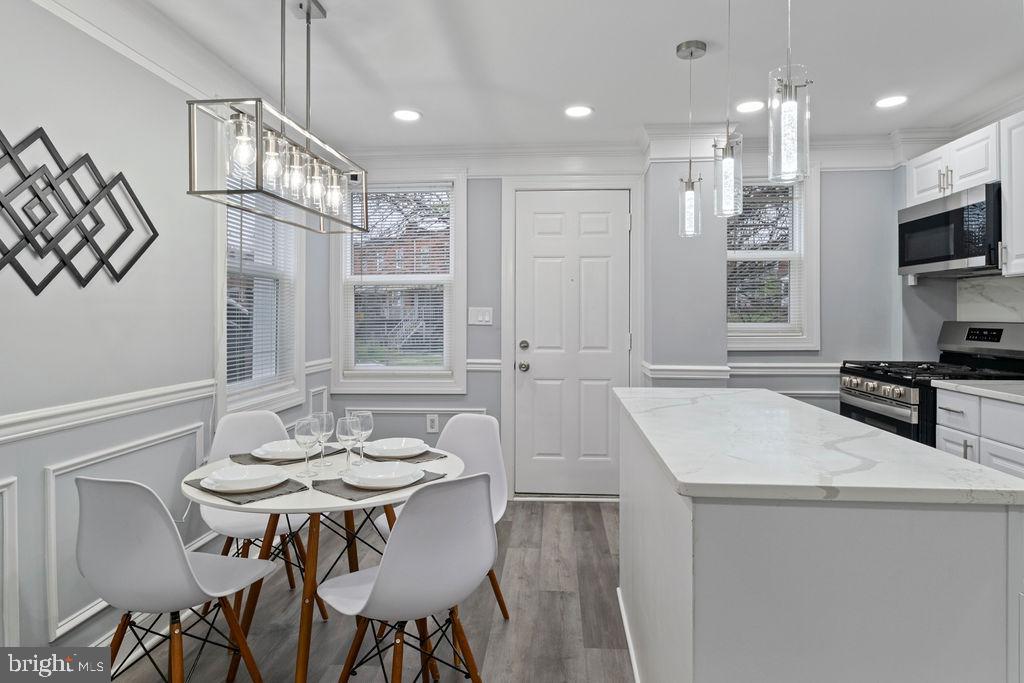 300 Denison Street Baltimore, MD 21229 - Photo 20 of 25 a kitchen with stainless steel appliances kitchen island a table and chairs in it