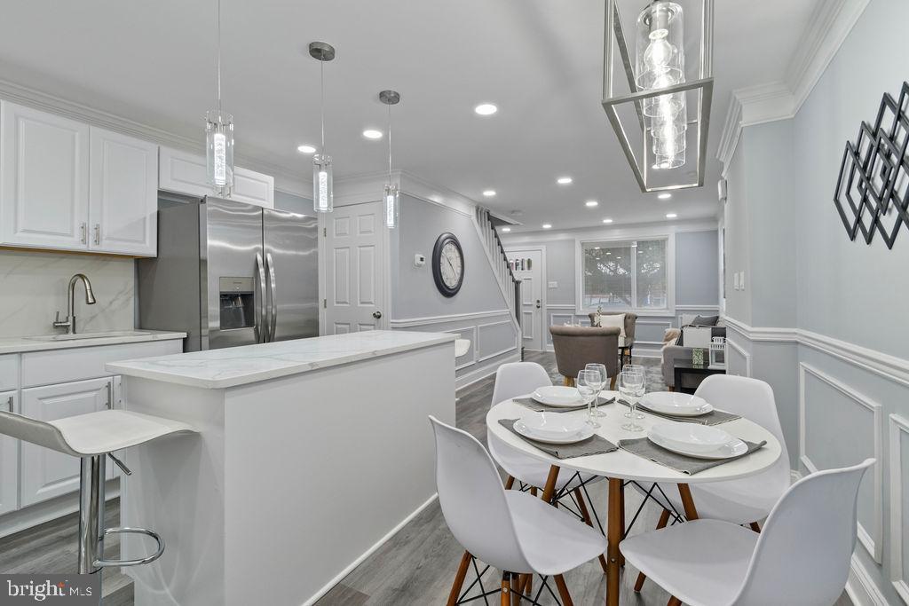 300 Denison Street Baltimore, MD 21229 - Photo 10 of 25 a kitchen with a dining table chairs and microwave