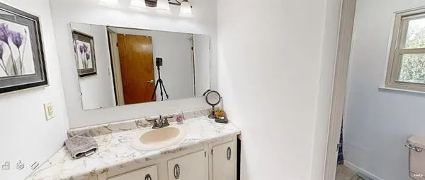 a bathroom with a granite countertop double vanity sink and a mirror