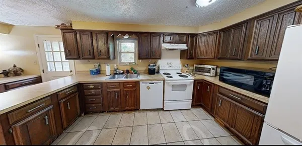 a kitchen with a sink stove top oven and cabinets