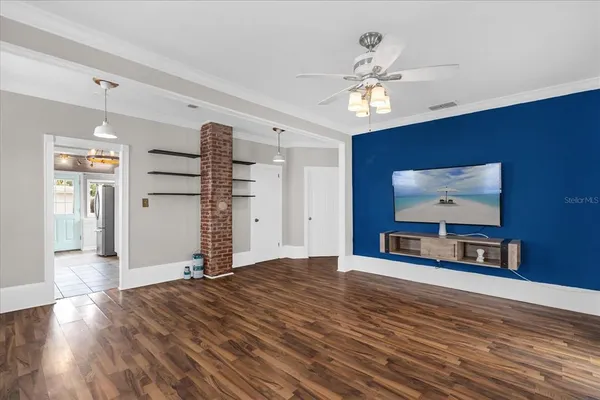 a view of an empty room with wooden floor