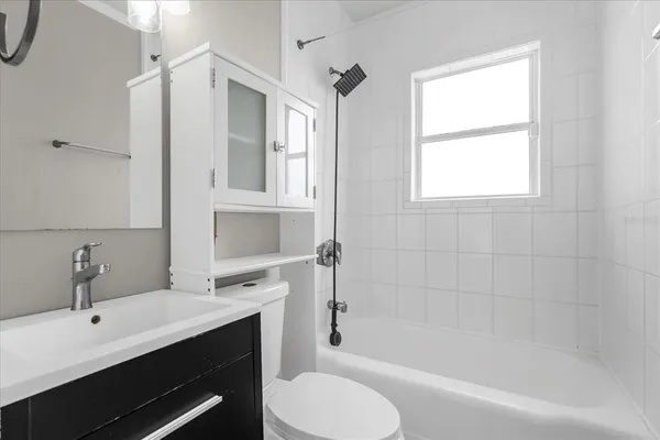 a bathroom with a granite countertop sink toilet a mirror and shower