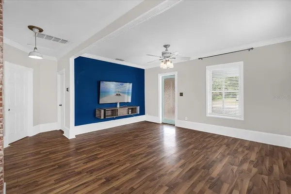 a view of an empty room with window and wooden floor