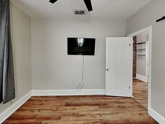 a view of a livingroom with wooden floor and a ceiling fan