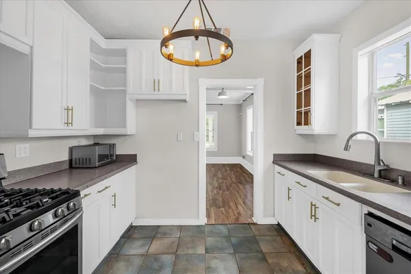 a kitchen with granite countertop a stove a sink and a granite counter tops