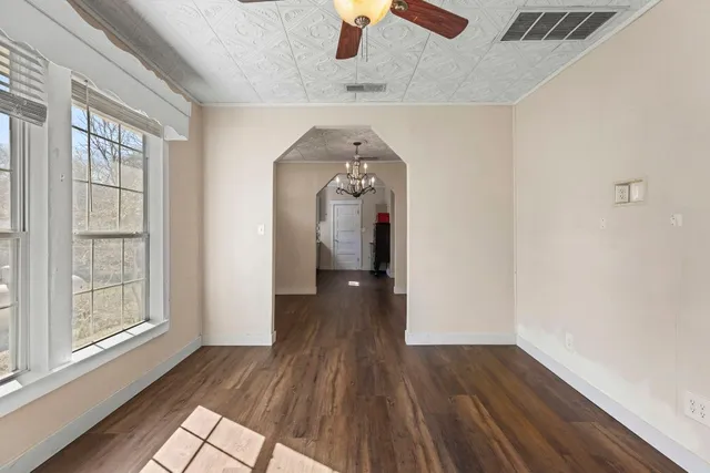 a view of a hallway with wooden floor and a chandelier