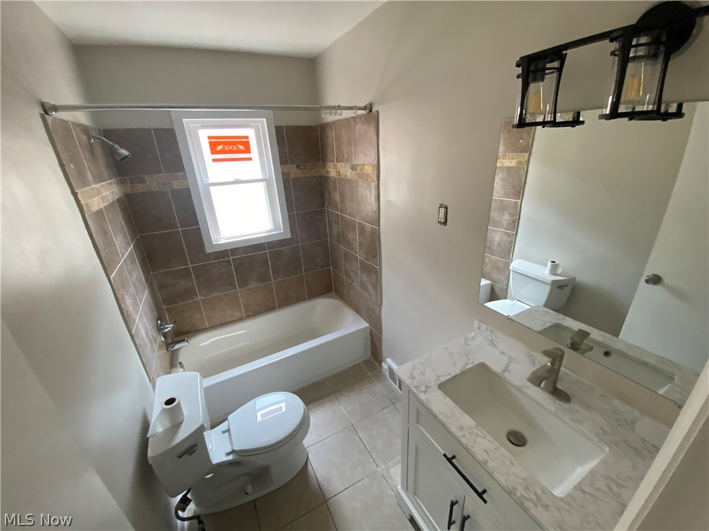 13117 Silver Road Garfield Heights, OH 44125 - Photo 14 of 20 Full bathroom with tiled shower / bath combo, tile flooring, toilet, and large vanity
