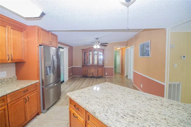 a kitchen with stainless steel appliances granite countertop a refrigerator and a sink