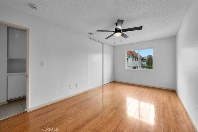 an empty room with a ceiling fan and wooden floor