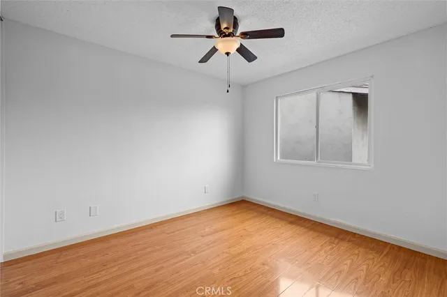 an empty room with a window and a ceiling fan