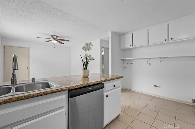 a kitchen with granite countertop a stove sink and cabinets