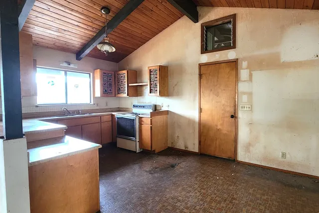 a kitchen with sink a stove and cabinets