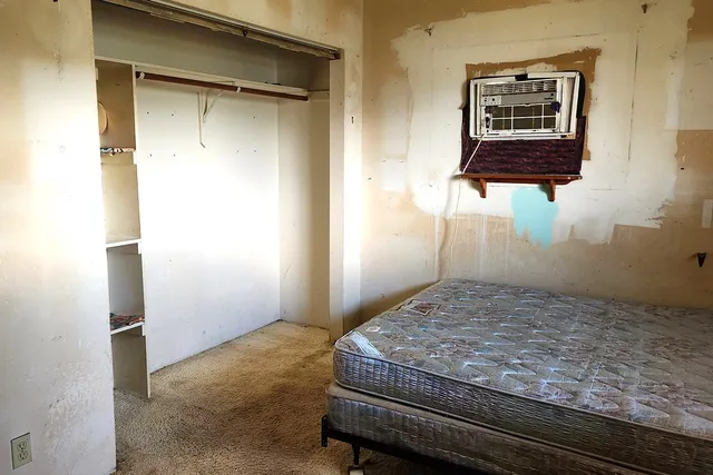 a bedroom with a bed and a window