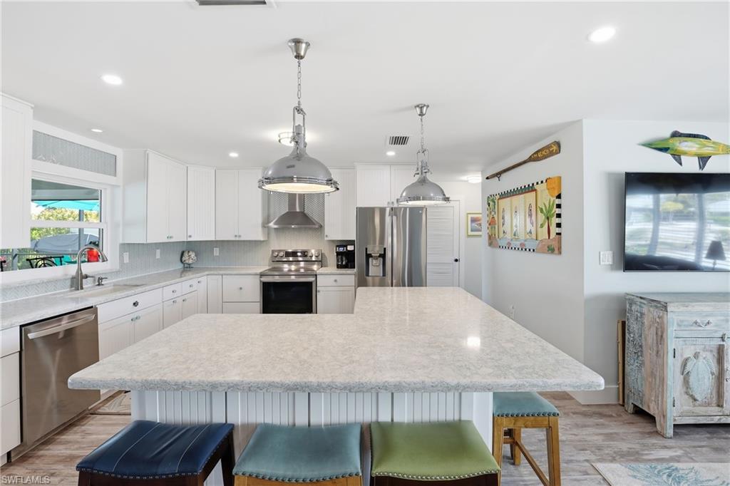 17 Palmview Boulevard Fort Myers Beach, FL 33931 - Photo 12 of 36 a large kitchen with a table and chairs in it