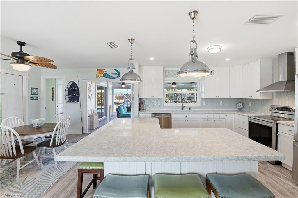 17 Palmview Boulevard Fort Myers Beach, FL 33931 - Photo 6 of 36 a kitchen with kitchen island a dining table and chairs
