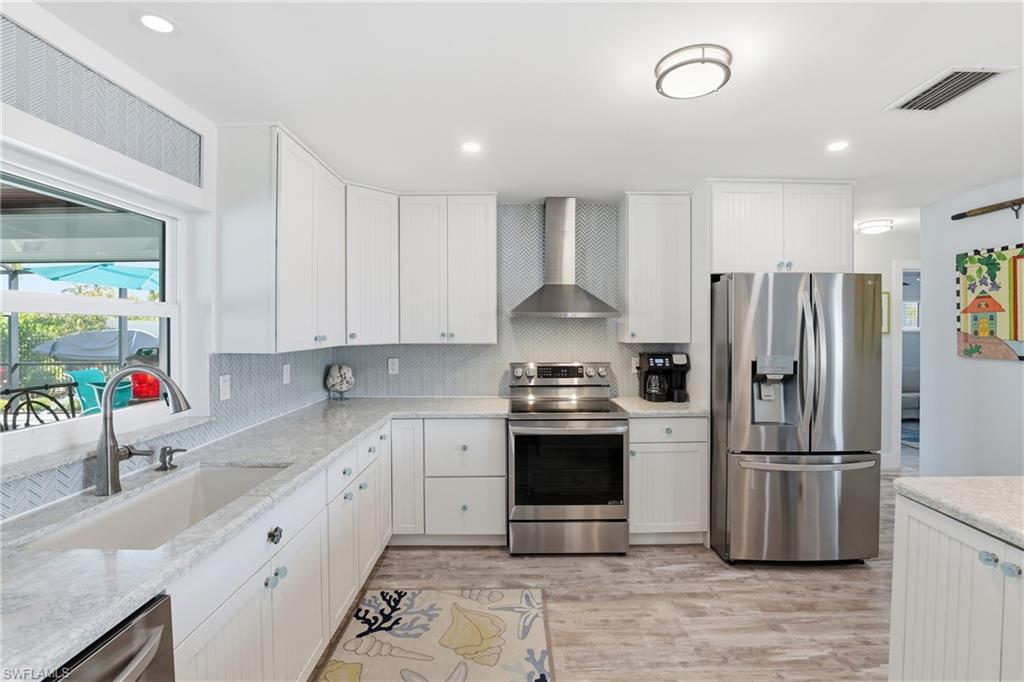 17 Palmview Boulevard Fort Myers Beach, FL 33931 - Photo 9 of 36 a kitchen with stainless steel appliances a refrigerator sink and microwave