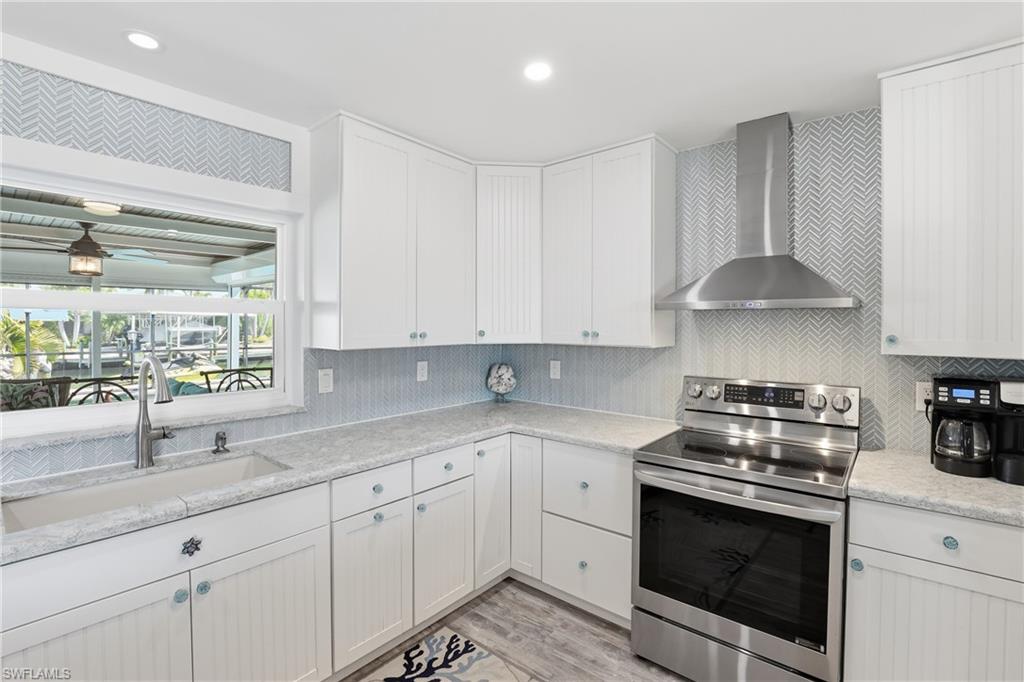 17 Palmview Boulevard Fort Myers Beach, FL 33931 - Photo 10 of 36 a kitchen with stainless steel appliances granite countertop white cabinets and a stove top oven