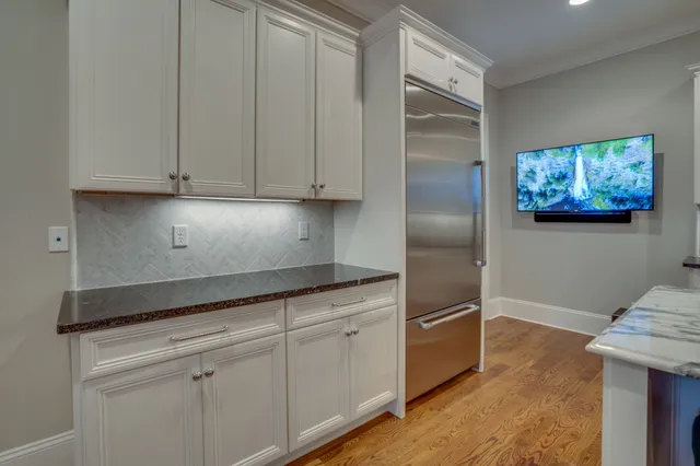 a view of a kitchen counter top space with stainless steel appliances granite countertop living room view living room and wooden floor