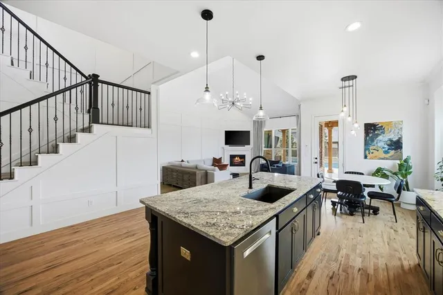 a open kitchen with stainless steel appliances granite countertop a stove and a wooden floor