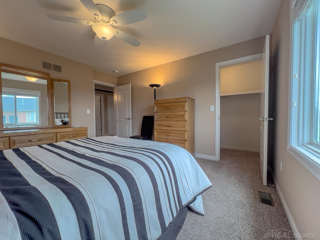 16070 Moore Park Road Macomb, MI 48044 - Photo 45 of 76 4th bedroom in SW corner upstairs features carpet, walk-in closet, & view of rear yard