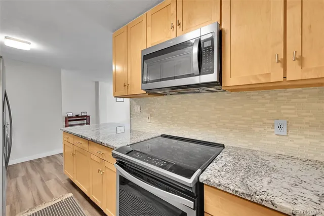 a kitchen with granite countertop stainless steel appliances and cabinets