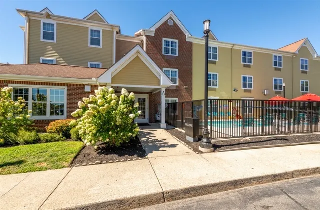 a front view of a house with a yard and potted plants