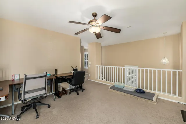a view of a workspace with furniture and a window